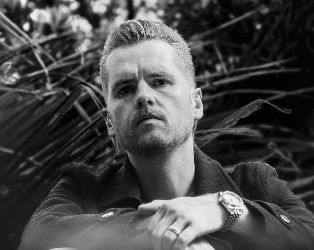 Black and white portrait of Dave Johnston among foliage